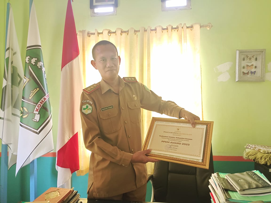 Kepala UPTD Puskesmas Unaaha memegang penghargaan dari Kemenkes